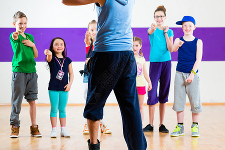 舞蹈老师给孩子提供健身班健身房女孩们快乐编舞男孩们工作室孩子们舞蹈家乐趣老师背景图片