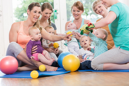 母亲和孩子组的青年妇女与婴儿一起玩耍小组活动游戏健身房孩子们女孩男生新生童年教养背景