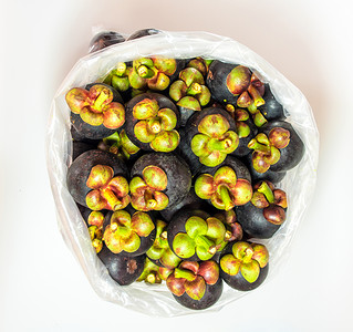 装在大塑料袋的新鲜芒果中批发热带营养食物水果饮食白色塑料紫色背景图片