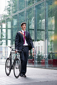 商务人士驾驶自行车通过城镇横穿城市背景图片