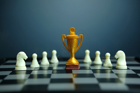 奖杯素材照片商业战略概念战略照片   金奖杯与象棋棋棋盘站在一起战术游戏风险领导者领导典当竞赛思维挑战控制背景