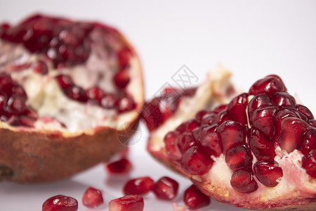 新鲜的成熟切片石榴水果 白种红种子孤立于白底粉色白色热带情调异国营养粮食宏观红色形象背景图片