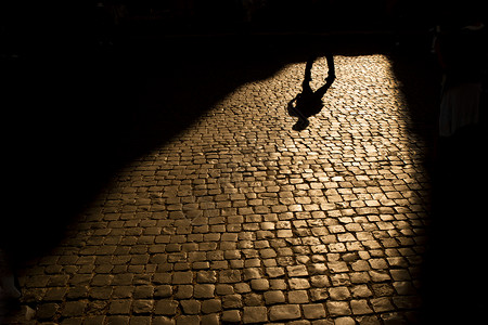 移动人行道影子投向街上日落旅行青年黑色投射石头人行道街道城市女性背景