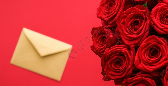 情人节的情书和送花服务 红色背景的豪华红玫瑰花团和纸信封红底展示玫瑰礼物平铺生日邮政花束送货奢华电子邮件背景图片