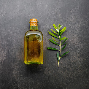 一杯橄榄油和橄榄枝放在深凝土底底部的杯子上沙拉叶子营养瓶子饮食美食食物树叶烹饪营养素背景图片