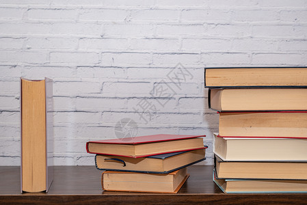 在黑木架上安排几本不同大小的书木头大学智慧教科书学校架子尺寸图书馆图书文学背景图片