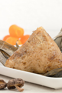 松子 龙船节的米面铺在有成分的明亮木制桌布上竹子盘子假期花生饺子庆典食物文化蛋黄叶子背景