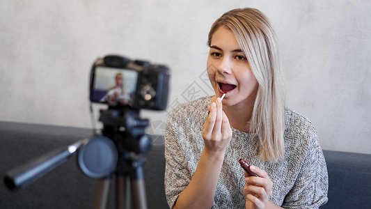 一位美容博客或视频博客表示并展示订户如何化妆相机播送商业教程女士唇线互联网女性博主化妆品背景图片