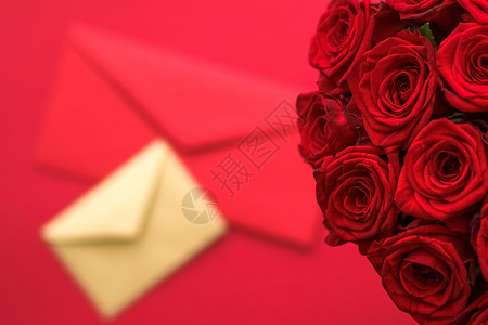 情人节的情书和送花服务 红色背景的豪华红玫瑰花团和纸信封红底卡片平铺邮件送货奢华礼物假期生日花朵玫瑰背景图片