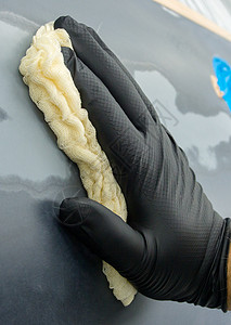 自动脱水拖把黑色手套内自动隔热器的手拿着一张特殊的餐巾纸 用来粉刷汽车表面背景