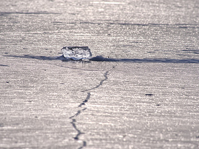 早晚温差冰冻湖上裂开的冰块碎片 光现象正在发生光谱液体冰壳裂缝温差边界薄冰水晶冰丘冻结背景
