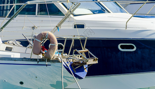 停泊在港口的游艇 游艇和摩托艇的特写 炎热的一天 码头的蓝水 蓝天娱乐力量梯子车轮海洋奢华快艇假期运动运输背景图片