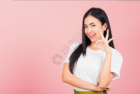 站着的女人 她做了手指好的符号标志 同意一边走微笑快乐手势学校学生乐趣幸福工人成功女性自信的高清图片素材
