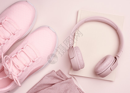 耳机鞋素材粉红色无线耳机 一双运动鞋和一张蜜蜂背景的笔记纸 最高视图背景