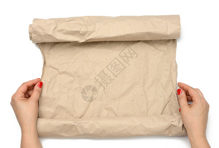 女性手握着一卷在白色背景上被孤立的棕色折面纸滚动商业卷曲小样纸板折叠羊皮纸文档工作室绳索背景图片