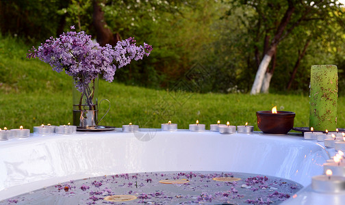 淡紫色菊苣室外浴缸中花朵和橙色切片的简要背景背景