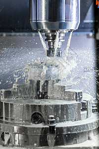 夹头5轴Cnc机器工业湿磨工艺的垂直照片 在压力下冷却液流和冷冻喷洒冷却剂铣削数控金工工作制造业主轴刀具金属植物背景