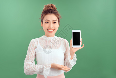 快乐 感动和印象深刻的年轻女性在智能手机屏幕上展示 因绿色背景而高兴与满意电话女士成人微笑空白细胞背景图片