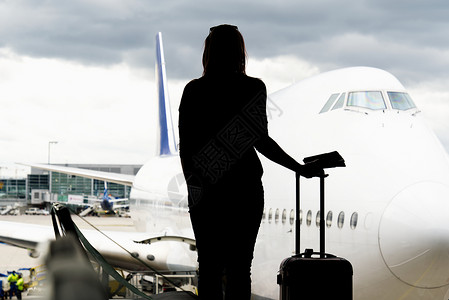 黑女人在机场大厅里寻找飞机的轮廓 错过或取消飞行的概念 笑声乘客空气游客飞机场压力行李孤独成人旅行运输背景图片
