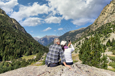 圣毛里奇中年旅游夫妇在西班牙圣毛里西和奥贝斯托尔多斯的比利牛斯山用移动电话拍照背景