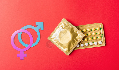 红色避孕套男性 女性性别在包装包和避孕药丸中标记安全套 并用热激素水泡避孕药背景
