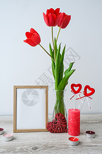 红色花藤框架假期模拟 玻璃花瓶中的郁金香花 在家里的木桌背景墙上装饰着相框 特写 母亲节设计理念桌子构图艺术风格问候语展示礼物推介会郁金香嘲背景