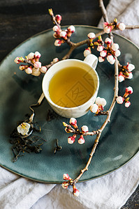 绿茶和桃花作为春季概念饮食粉笔杯子桌子树叶玻璃茶叶勺子樱花筷子背景图片