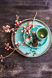 绿茶和桃花作为春季概念桌子粉笔樱花玻璃饮料勺子乡村树叶饮食茶叶背景图片