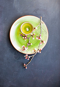 绿茶和桃花作为春季概念树叶粉笔勺子饮料樱花筷子桌子乡村餐巾玻璃背景图片