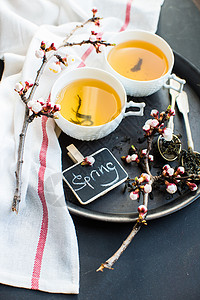 绿茶和桃花作为春季概念饮食勺子筷子茶叶乡村杯子樱花玻璃餐巾饮料背景图片
