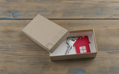 新作为红色礼品盒中有钥匙的微型房子 住房作为礼物 在彩票中赢得一间公寓 继承财产 节日折扣 以低价购买公寓 房地产销售惊喜投资保险婚礼展示背景