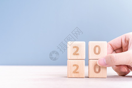 2019一路向前摘要 2020 2019 新年倒计时设计理念  女性在木桌和蓝色背景上拿着木块立方体特写复制空间日历创造力灰色金融数字成就女士预背景