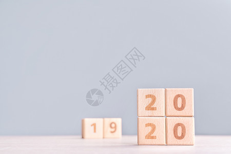 摘要 2020 2019 新年倒计时设计理念木桌上的木块立方体和低饱和度蓝色背景特写复制空间日历商业战略派对正方形数字审查成就桌背景图片