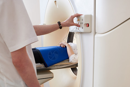 五十肩妇女通过计算机化轴心扫瞄器进行X光CAT扫描仪 医生操作MRI设备背景