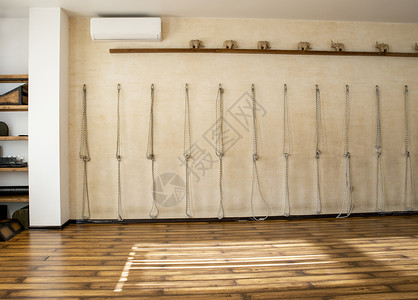 艾扬格在瑜伽工作室的墙上绑着银环的天主教绳子 大结 锻炼 运动 室内伸展活动概念健美操力量绳索讲师姿势灵活性瑜珈老师女性女士背景