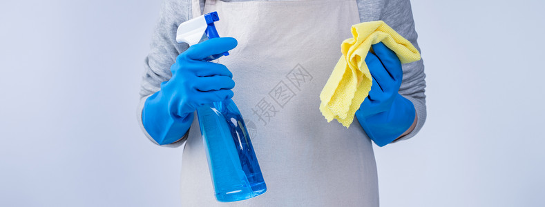 病毒来袭穿围裙的年轻女管家正在用蓝手套 湿黄抹布 喷洒瓶装清洁剂 特写 复制空间 空白设计概念来打扫女士家务女孩女佣毛巾卫生蓝色办公室女背景