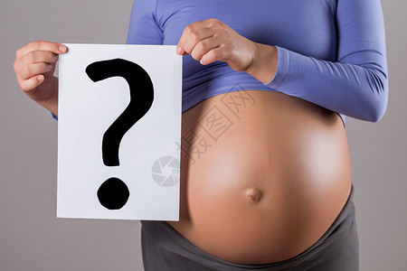 孕妇问号持有带问号的纸片的孕妇胃部背景