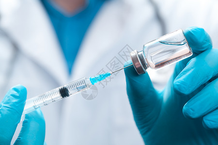 医生持有抗冠状病毒疫苗的毒物药物实验室流感医院治疗安瓿疫苗小瓶手套剂量背景图片