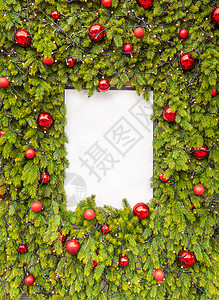 红色花藤框架创意布局由圣诞树枝和白皮书卡片制成 平躺着复制空间新年概念创造力白色松树艺术红色笔记假期木板季节庆典背景