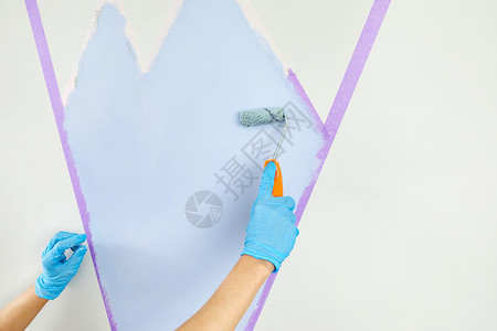 用油漆滚筒和遮蔽胶带手绘墙 粉刷公寓翻新与蓝色疼痛高清图片