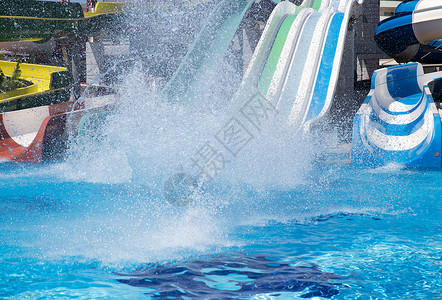 滑动滑翔水幻灯片孩子飞溅公园活动成年人速度太阳童年闲暇蓝色背景