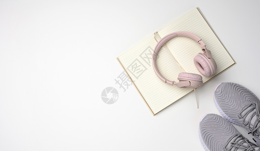 耳机鞋素材粉红色无线耳机 一双运动鞋和一张白色背景的笔记纸 最高视图背景
