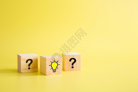 创意黄色问号木块立方体上的灯泡图标和问号打印屏幕背景