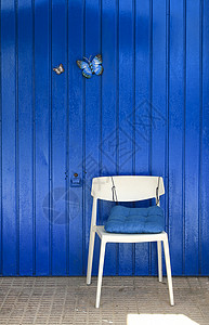 蝴蝶椅子有两只装饰性蝴蝶的多彩蓝色金属门背景