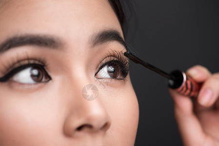 化妆品和化妆品概念 亚洲女性做化妆师的眼睫毛黑面纱眼睛女士蓝色刷子女孩黑色背景图片