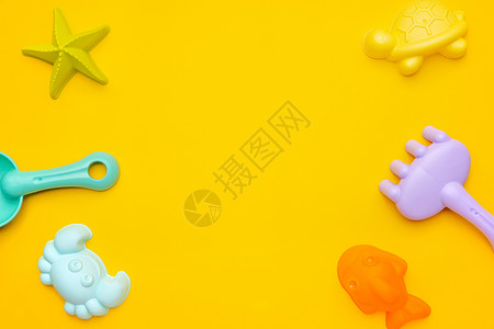 浅海和沙坑黄色背景上的塑料沙滩玩具柔和的颜色 精细运动概念的发展 创意游戏和夏季概念活动孩子娱乐海岸晴天红色太阳婴儿闲暇孩子们背景