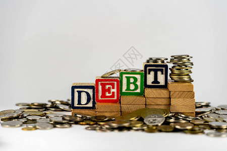 与木块和硬币的债务概念 木块上的债信被钱包围预算现金生长养老金投资字母商业贷款键盘积木背景图片