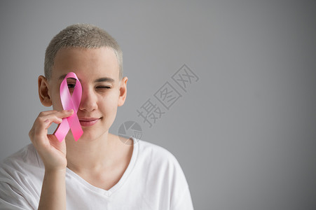 全国癌症日短发的年轻女子身着白色T恤 带着粉色丝带 作为白种背景乳腺癌的象征物考试世界肿瘤学全世界机构帮助治疗疾病幸存者癌症背景