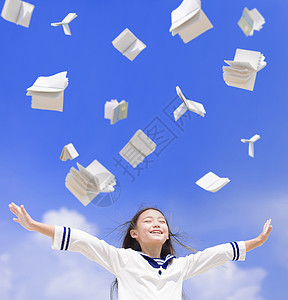 兴奋的女学生把书扔在空中手势高清图片素材