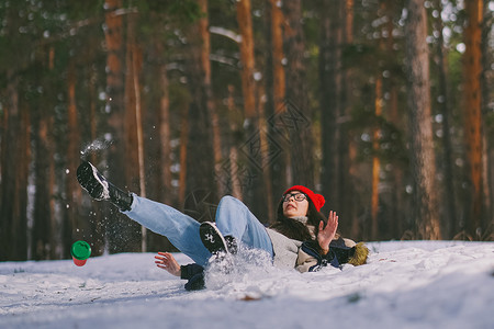 当心坠落女孩掉在森林里的湿雪上背景